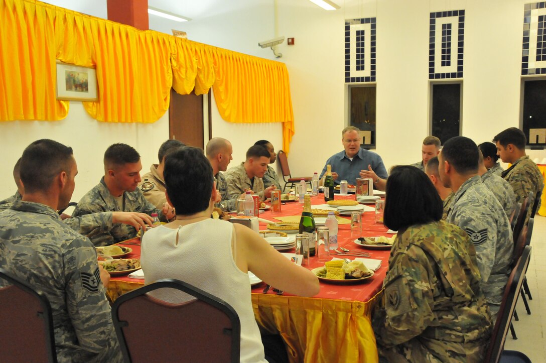 Deputy Secretary of Defense Bob Work talks with service members during a Thanksgiving meal at Al Udeid Air Base, Qatar. There were 14 service members who ate with the Honorable Mr. Work and his wife Mrs. Cassandra Work. The Deputy Secretary of Defense started off with introductions but quickly got to the important stuff; thanking the service members and eating turkey and stuffing. (U.S. Air Force Photo by Tech. Sgt. Terrica Y. Jones)