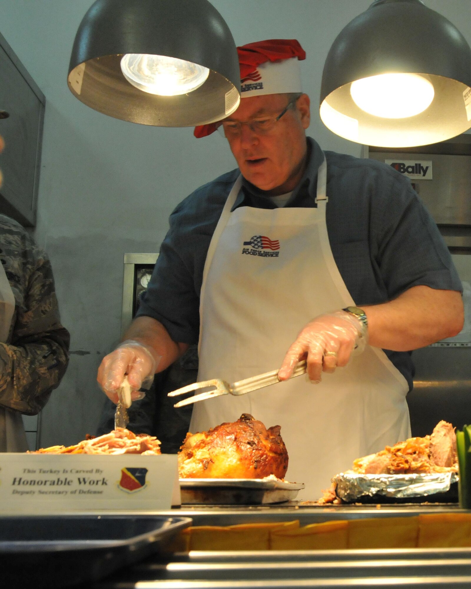 Deputy Secretary of Defense Bob Work carves turkey for service members at the Blatchford-Preston Complex dining facility at Al Udeid Air Base, Qatar. Each dining facility prepared a Thanksgiving meal for the troops to enjoy. Along with the Thanksgiving classics there were decorated cakes on display with encouraging messages. (U.S. Air Force Photo by Tech. Sgt. Terrica Y. Jones)