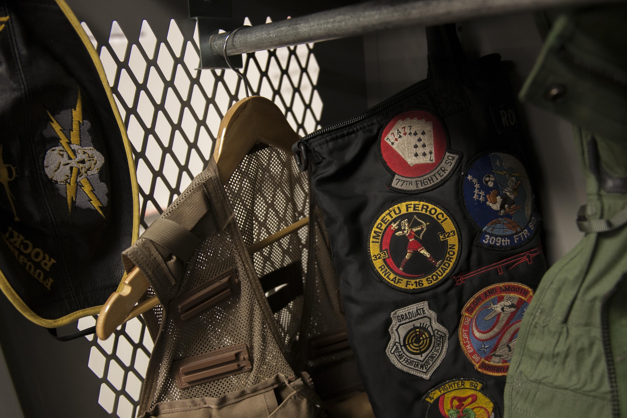 455th Expeditionary Operation Group Commander Col. Henry Rogers' helmet bag, covered in patches from various fighter squadrons he's flown with, hangs in a locker at the 421st Expeditionary Fighter Squadron at Bagram Airfield, Afghanistan, Nov. 27, 2015. Rogers became one of only a couple-hundred F-16 pilots worldwide to surpass 3,000 flying hours in the F-16 on Oct. 29, 2015. He followed that up with reaching 1,000 combat hours in the fighter workhorse on Nov. 7, 2015. (U.S. Air Force photo by Tech. Sgt. Robert Cloys/Released)
