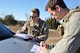 Instructor Staff Sgt. Steven Smith helps Senior Airman Phil Schneider, a student Joint Terminal Attack Controller, prepare coordinates to call in a simulated air strike during the class’s field training exercise south of Warsaw, Missouri on November 19. Academic portions of the class rely on JTACs playing the role of pilots in hypothetical missions, but the exercise gives students the opportunity to speak with experienced pilots from the 442d Fighter Wing over the radio in realistic scenarios. Warsaw has hosted the exercises since 1993. (U.S. Air Force photo/ Technical Sgt. Emily F. Alley)