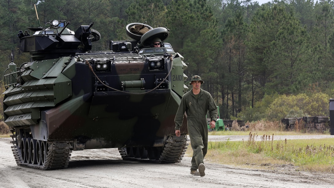 An Amphibious Assault Vehicle is guided by an amphibious assault vehicle crewman after completing the Heavy Brigade Combat Team qualification course at Marine Corps Base Camp Lejeune, North Carolina, Nov. 20, 2015. The qualification is a course of fire that requires crews to engage several targets while taking time and accuracy into account, and trying to score a possible 1,000 points.