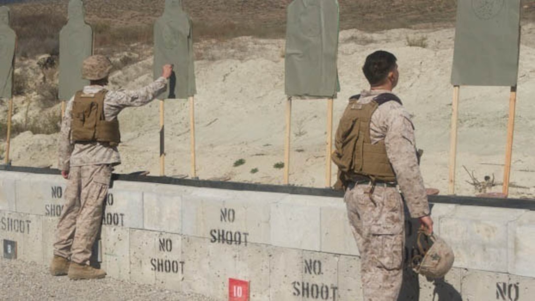 Instructors of the Division Schools Urban Leaders Course score targets after pre-qualification for close-quarters combat engagement at Marine Corps Base Camp Pendleton, California, Oct. 26, 2015. If any Marine missed more than 18 shots during qualification, they have one more chance to re-qualify.