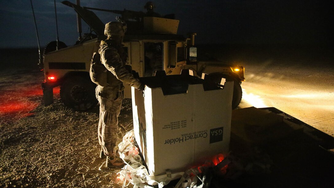 U.S. Marines with Company C, 1st Battalion, 7th Marine Regiment, Special Purpose Marine Air Ground Task Force-Crisis Response-Central Command, collect a cargo pallet from an aerial delivery coordinated by Combat Logistics Battalion 1 at an undisclosed location in Southwest Asia during a mission readiness exercise Nov. 24, 2015.  The training exercise consisted of a scenario where a forward operating base in the area of responsibility required SPMAGTF-CR-CC reinforcement as part of its crisis response mission spanning 20 nations in the U.S. Central Command area of responsibility.  