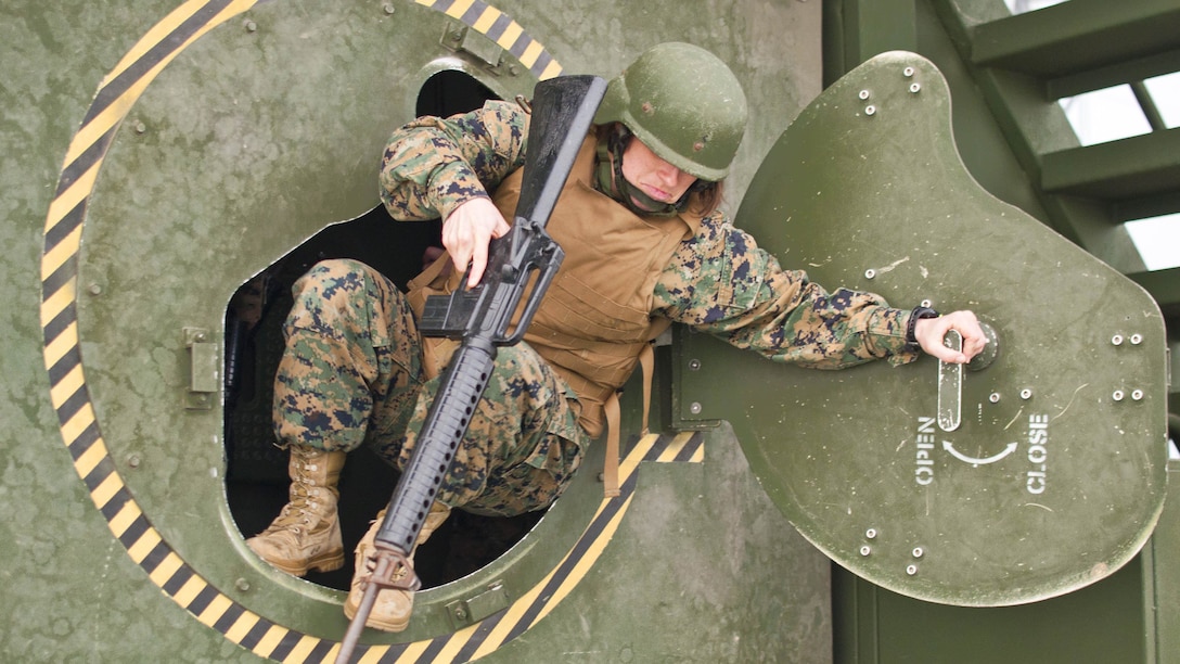 Captain Ericka Johnson, a Legal Service Support Section defense attorney, conducts egress training at the Quantico Reserve Support Unit High Mobility-Multipurpose Wheeled Vehicle (HUMMWV) Egress Assistance Trainer (HEAT) Nov. 20 to practice rollover training. The repetitive training exercise duplicates the effort required to exit an inverted vehicle.