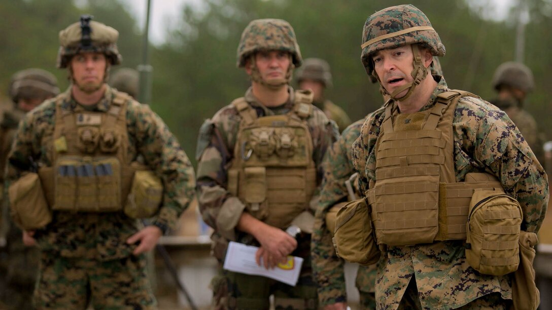 Col. Joseph Allena, the commanding officer of 10th Marine Regiment, briefs a group of Marines during a live-fire training event at Camp Lejeune, N.C., Nov. 19, 2015. 1/10 tested the new M1122 practice round. The M1122 is more cost efficient and more resourceful than older ammunition used during training events. 