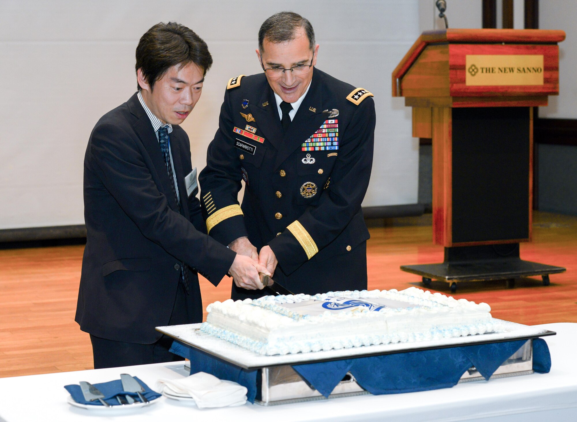 Gen. Michael Scaparrotti, United Nations Command commander, right, and a UN reception attendee, left, cut a cake during the UN Day 70th Anniversary Celebration in Tokyo, Japan, Nov. 16, 2015. The day provides an opportunity for the UNC, a unified command structure for the multinational military forces supporting South Korea, to show its appreciation for the ongoing support from sending states, supporting organizations and Japan, and to reinforce the value to regional security and stability. Attendees include ambassadors, diplomats, members of the Japanese Ministry of Foreign Affairs and Ministry of Defense, Japanese Self-Defense Forces and United States Forces, Japan, senior military officers. (U.S. Air Force photo by Airman 1st Class Elizabeth Baker/Released)