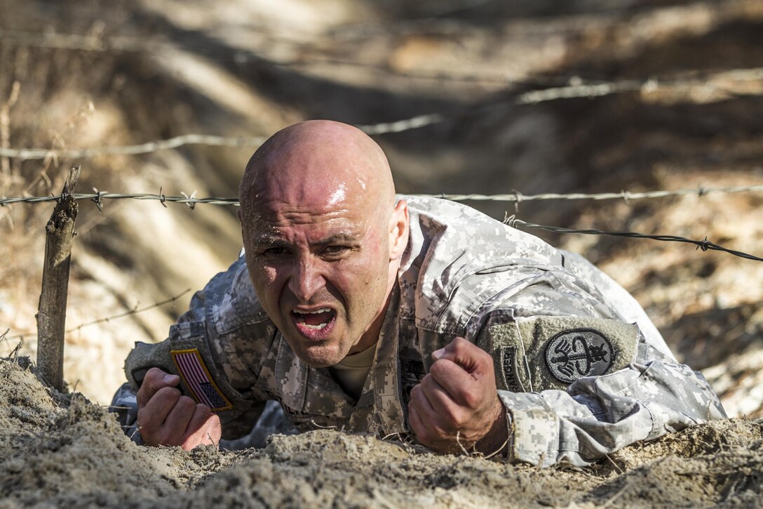 Army 1st Sgt. Ricardo Gutierrez low-crawls under a wire obstacle during the assessment phase of the Best Ranger competition on Fort Jackson, S.C., Nov. 24, 2015. Gutierrez is one of three Fort Jackson soldiers fighting for a position on a two-soldier team that will represent the post during the 33rd annual competition on Fort Benning, Ga., in April 2016. U.S. Army photo by Sgt. 1st Class Brian Hamilton