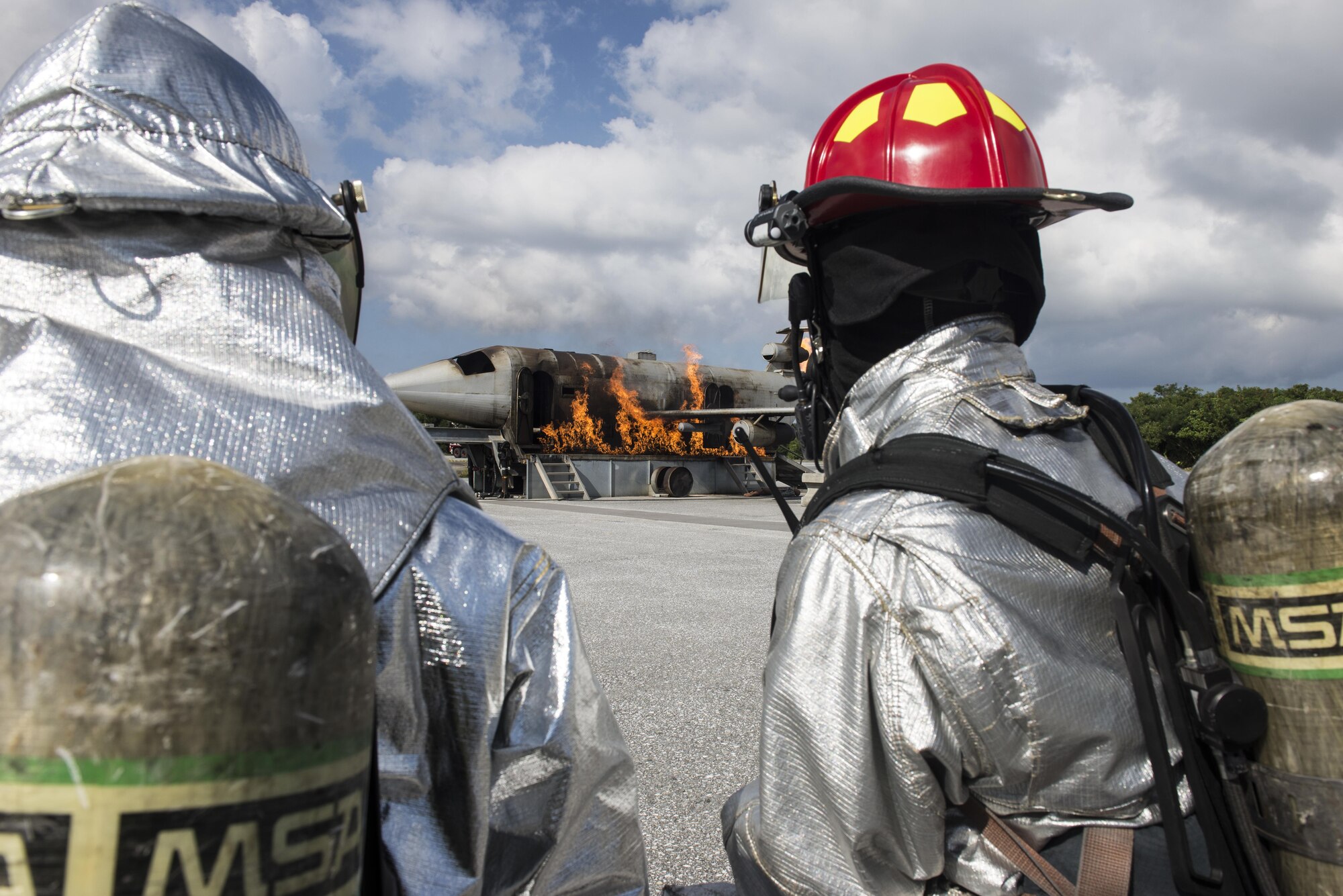 Kadena Fire Department firefighters conduct live-fire training with firefighter cadets from Tokyo and Okinawa, Nov. 24, 2015, at the fire training pit on Kadena Air Base, Japan. The fire department demonstrated how they extinguish aircraft fires with the fire trucks on a flight line. (U.S. Air Force photo by Senior Airman Omari Bernard)