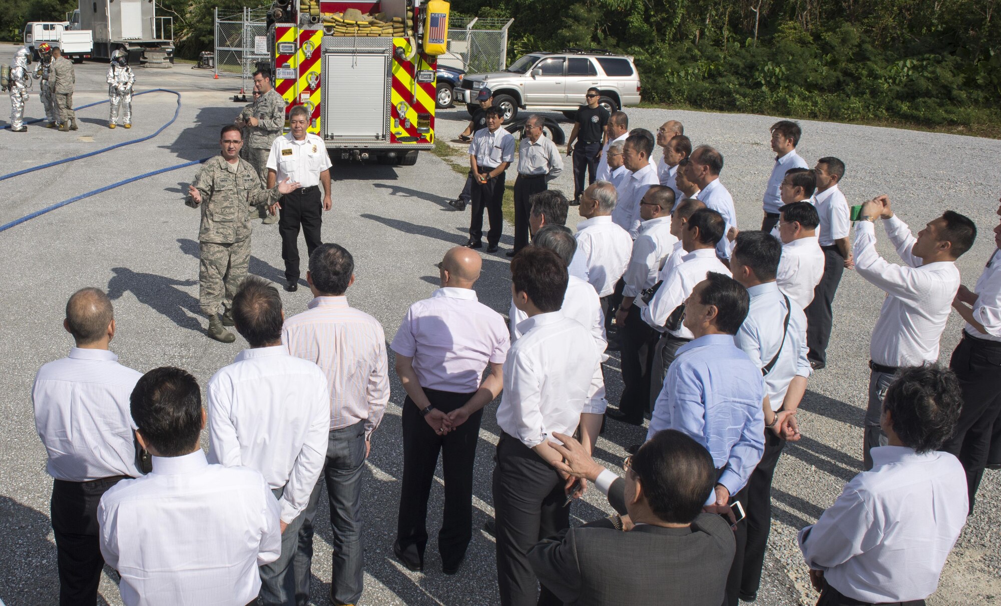 U.S. Air Force Master Sgt. Jon Ammon, 18th Civil Engineer Squadron assistant chief of operations, gives a brief introduction to a live firefighting demonstration, Nov. 24, 2015, at Kadena Air Base, Japan. Firefighters from the 18th CES performed a demonstration for Tokyo and Okinawan firefighter cadets and explained the methods and equipment used to extinguish aircraft fighters on an air base. (U.S. Air Force photo by Senior Airman Omari Bernard)