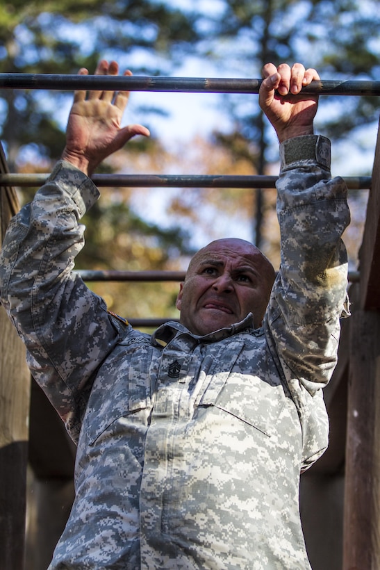 Army 1st Sgt. Ricardo Gutierrez grasps the last rung of the monkey bar obstacle on the confidence course during the assessment phase of the Best Ranger Competition on Fort Jackson, S.C., Nov. 24, 2015. Gutierrez is one of three Fort Jackson soldiers fighting for a position on a two-soldier team that will represent the post during the 33rd annual competition on Fort Benning, Ga., in April 2016. U.S. Army photo by Sgt. 1st Class Brian Hamilton