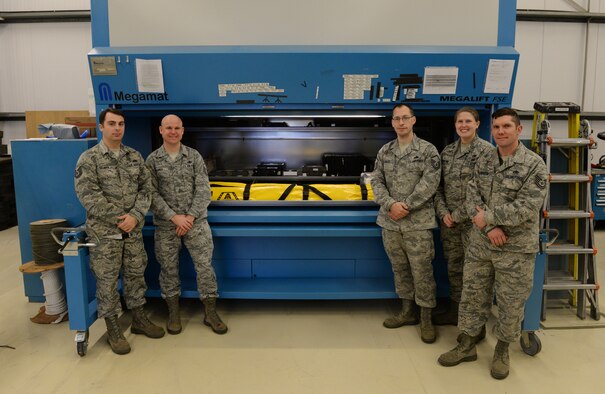 Members of the 95th Reconnaissance Squadron stationed at RAF Mildenhall, UK, stand beside the Megamat MegaLift FSE, a $25,000 vertical storage system, at Mildenhall Nov. 24, 2015. The MegaLift recently broke, and rather than scrapping the metal or paying nearly $7,000 in new parts, the team made use of the Air Force Repair and Enhancement at RAF Lakenheath, ultimately repairing the equipment for only $140. (U.S. Air Force photo by Staff Sgt. Micaiah Anthony/Released)