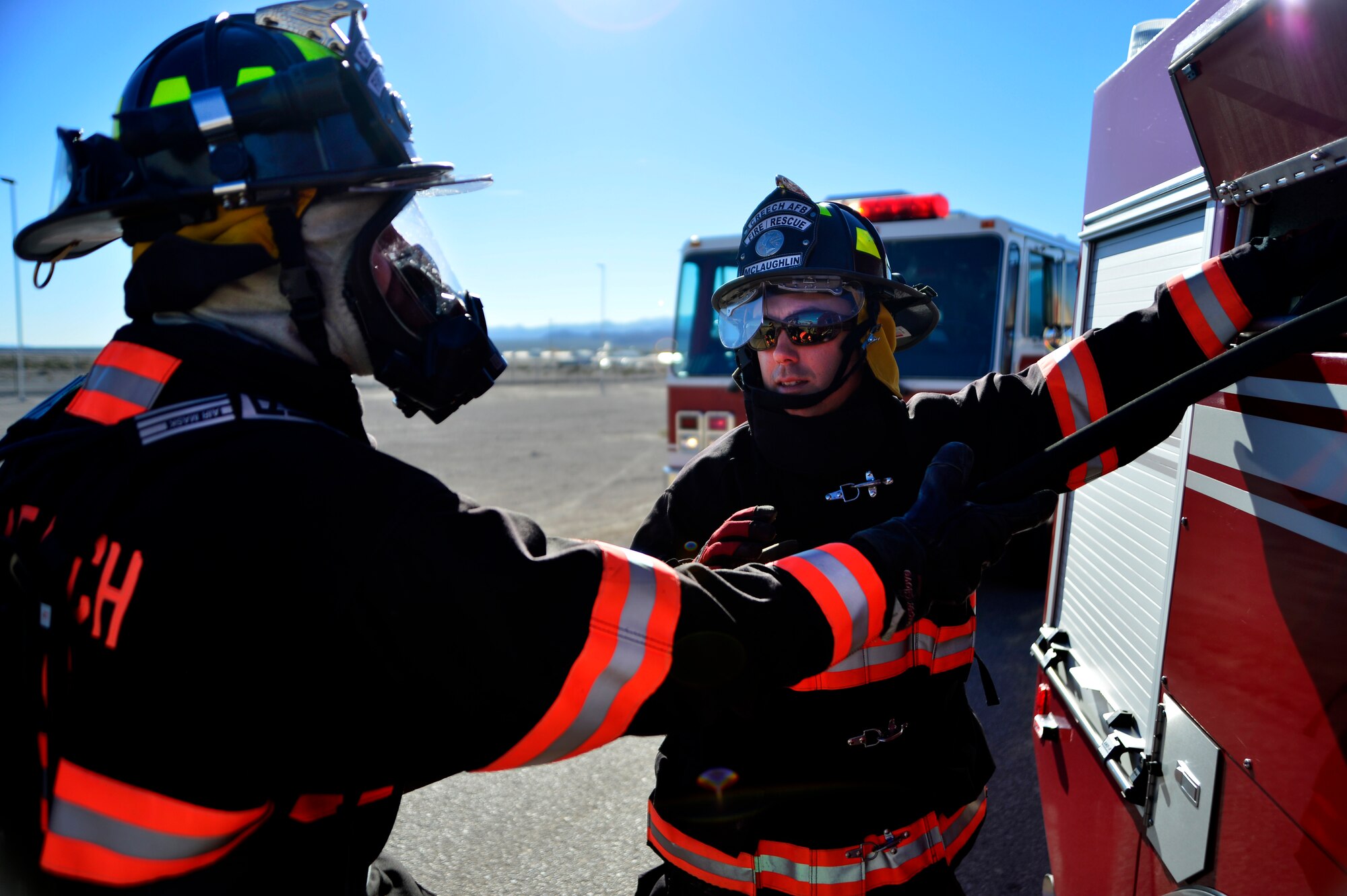 Kevin, left, and Landon, 99th Civil Engineering Squadron fire fighters, put away a fire hose after a munitions storage area exercise Nov. 24, 2015, at Creech Air Force Base, Nevada. The exercise is a semi-annual event to keep fire fighters current on procedures to put out a fire near live ordnance. (U.S. Air Force photo by Airman 1st Class Christian Clausen/Released)