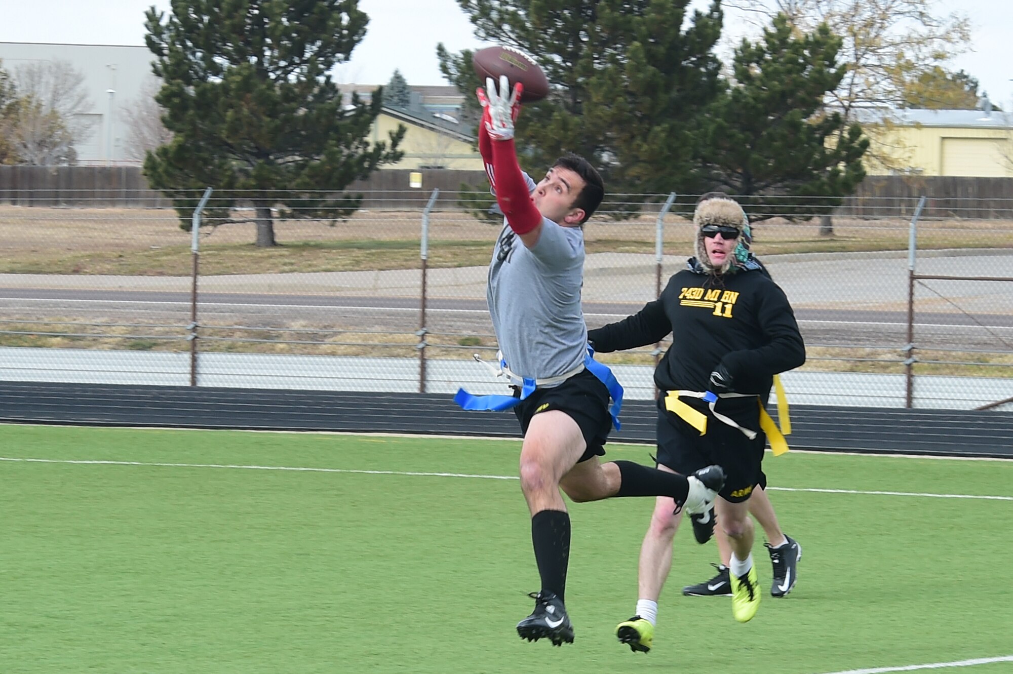 A member of the 743rd Military Intelligence Battalion Senior NCOs team leaps to make a catch Nov. 25, 2015, on Buckley Air Force Base, Colo. The final outcome of the annual 743rd MI Battalion Turkey Bowl game was 24 to 18 with the officers walking away with the victory. (U.S. Air Force photo by Airman 1st Class Luke W. Nowakowski/Released) 
