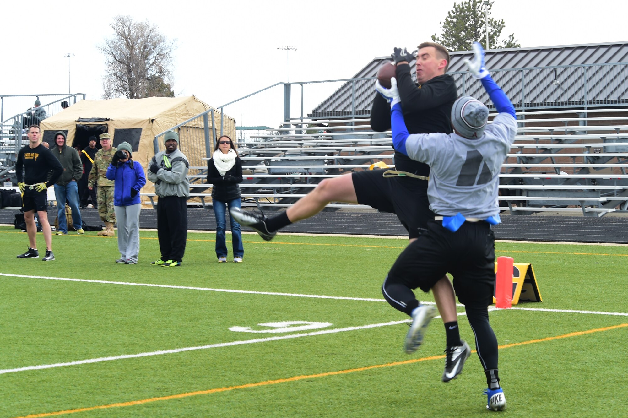 A member of the 743rd Military Intelligence Battalion officer team jumps to make a catch against defender Nov. 25, 2015, on Buckley Air Force Base, Colo. The final outcome of the game was 24 to 18 with the officers walking away with the victory. (U.S. Air Force photo by Airman 1st Class Luke W. Nowakowski/Released)