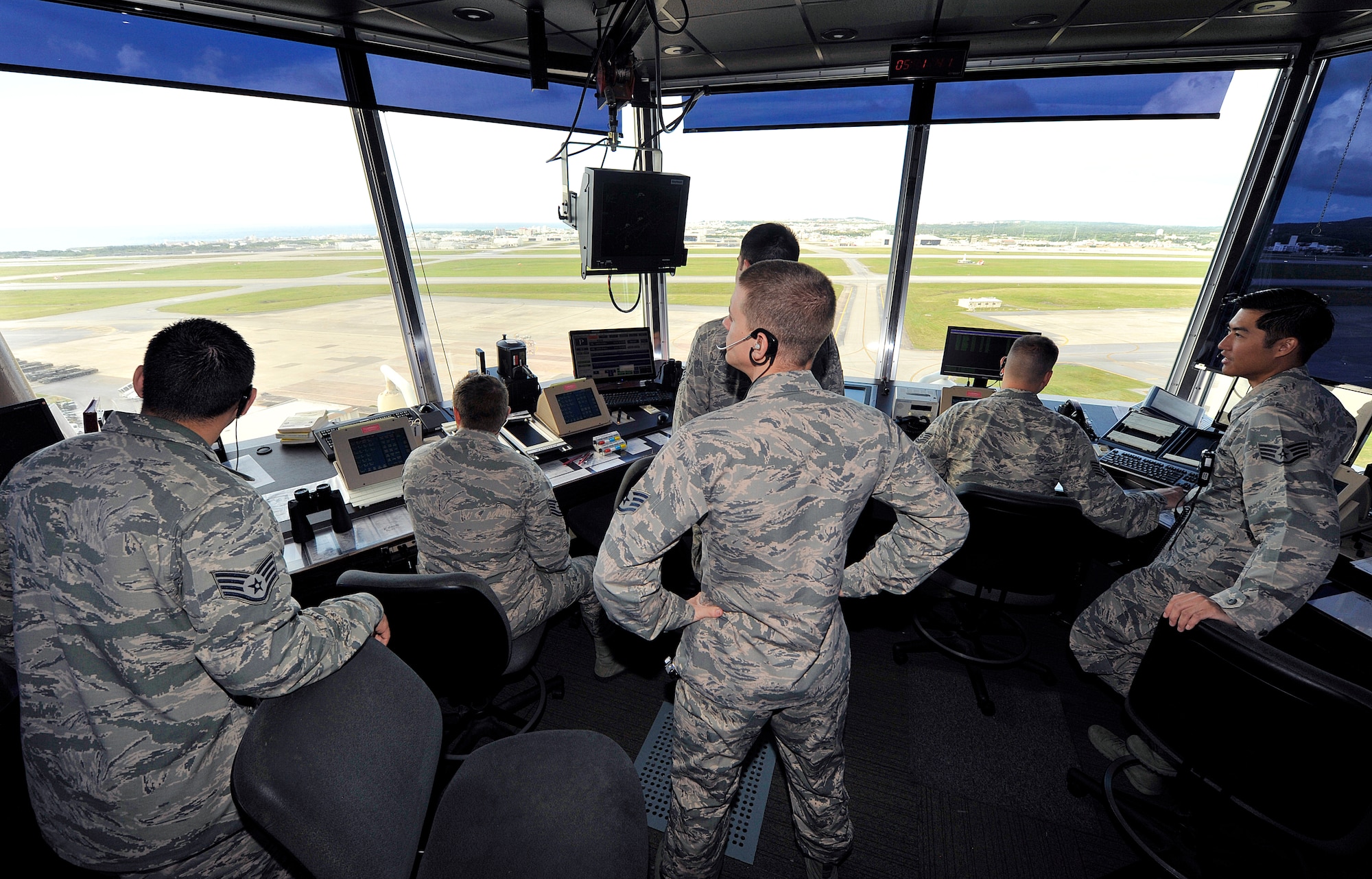 Air traffic controllers from the 18th Operations Support Squadron visually scan the Kadena flight line for safety risks in the ATC tower, Nov. 30, 2015, at Kadena Air Base, Japan. Air traffic controllers require extensive training so they can ensure the safety of flight operations for multiple airframes while minimizing delays. (U.S. Air Force photo by Naoto Anazawa)