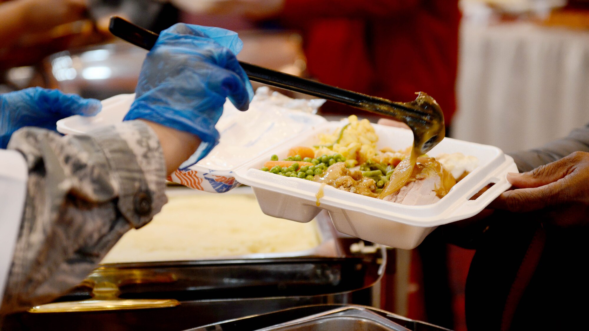 U.S. Air Force Senior Master Sgt. Karla Jeremiah-Griffith, 31st Dental Squadron senior enlisted leader, dishes up a serving of gravy Nov. 26, 2015, at Aviano Air Base, Italy. Jeremiah-Griffith and wing leaders served La Dolce Vita dining facility and La Bella Vista Club customers on Thanksgiving Day. (U.S. Air Force photo by Staff Sgt. R.J. Biermann/Released)