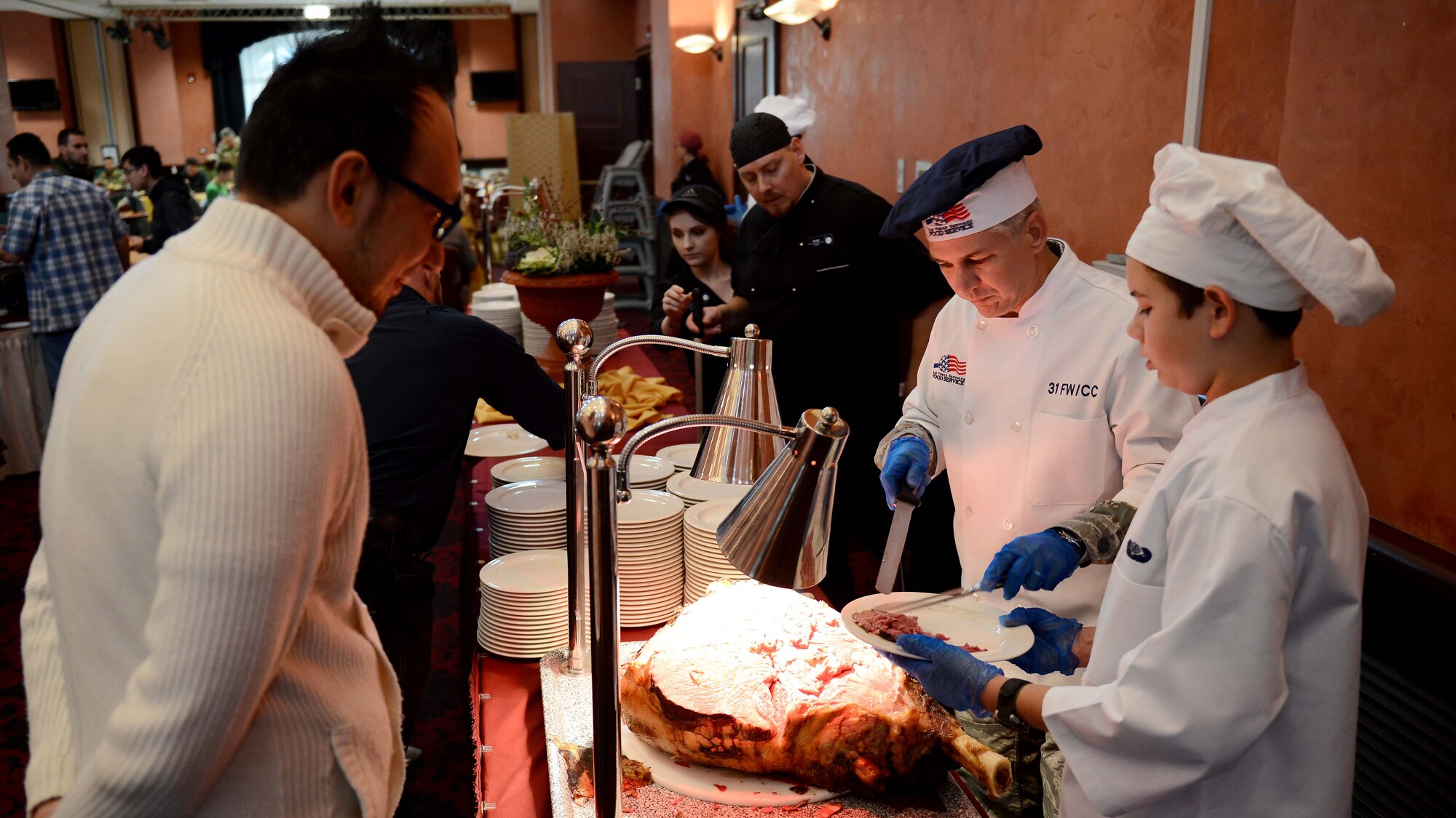 U.S. Air Force Brig. Gen. Barre R. Seguin, 31st Fighter Wing commander (second from right), and his son, Barre (right), serve up an entrée Nov. 26, 2015, at Aviano Air Base, Italy. Wing leaders served La Dolce Vita dining facility and La Bella Vista Club customers on Thanksgiving Day. (U.S. Air Force photo by Staff Sgt. R.J. Biermann/Released)
