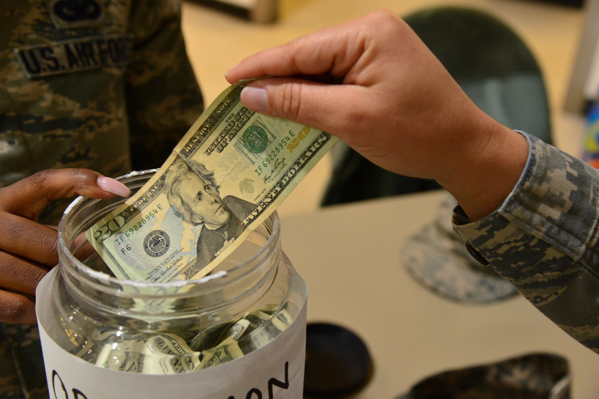 Money is donated to Operation Warm-Heart at the Commissary Nov. 24, 2015, at Malmstrom Air Force Base, Mont. Operation Warm-Heart has provided 301 Malmstrom families with food baskets since October 2013, totaling $6,165. (U.S. Air Force photo/Airman Daniel Brosam)