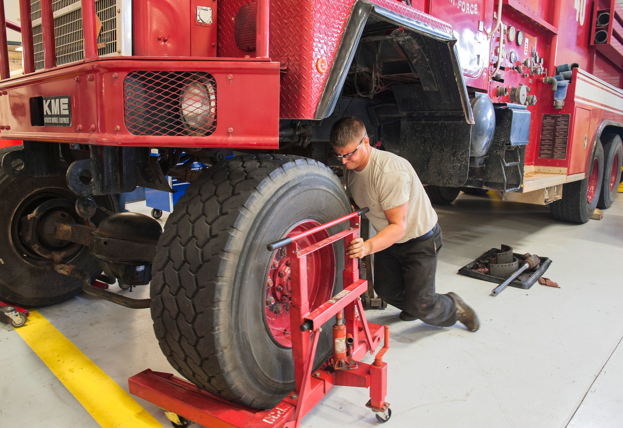 Airman 1st Class Thomas Zak, 96th Logistics Readiness Squadron, pushes a 5,000 pound serviceable axle and differential assembly under Tanker 46 Nov. 10 at Eglin Air Force Base, Fla. The part was procured from a Tyndall AFB fire truck slated for the salvage yard and re-installed into Tanker 46, a broken 1989 model 2,000 gallon water tanker fire truck. The repair job saved the Wing $25 thousand and maintained response readiness. (U.S. Air Force photo/Ilka Cole)