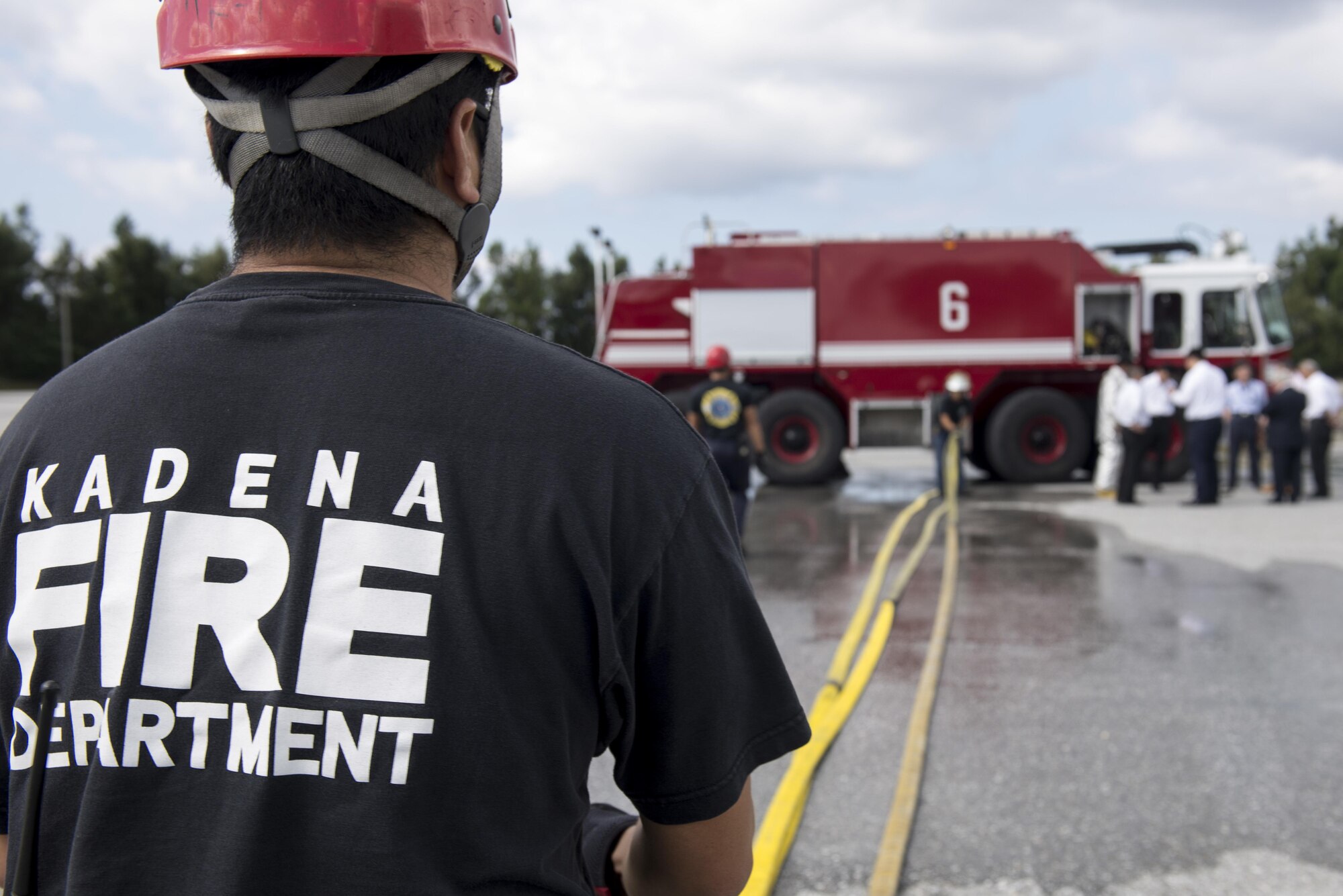 Firefighters from the Kadena Fire Department wring out a fire hose before storing it on a fire truck, Nov. 24, 2015, at the fire training pit on Kadena Air Base, Japan. The 18th Civil Engineer Group conducted a live-fire training demonstration for firefighter cadets from Tokyo and Okinawa as a way to increase relations and emergency effectiveness with Japanese counterparts. (U.S. Air Force photo by Senior Airman Omari Bernard)