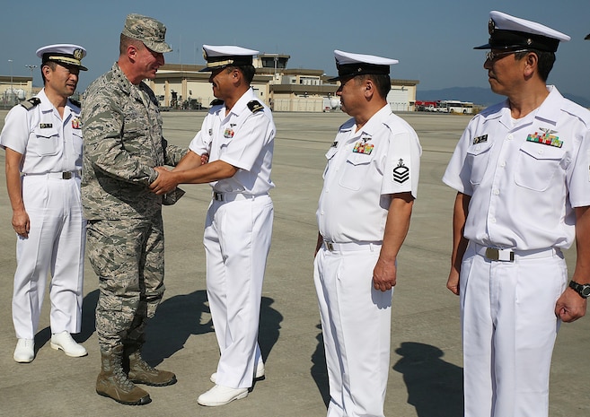 U.S. Air Force Lt. Gen. John L. Dolan shakes hands with Japan Maritime Self-Defense Force Warrant Officer Fumio Ootaki, first, JMSDF Chief Petty Officer Yukihiro Kamouchi, second, and JMSDF Chief Petty Officer Noriaki Tazaki, third, with Air Rescue Squadron 71, during a visit to the JMSDF hangar at Marine Corps Air Station Iwakuni, Japan, Sept. 29, 2015. Dolan took time during his visit to the station to reconnect with the Japanese service members who saved his life over two decades ago. While serving as an F-16 instructor pilot, flight examiner, and assistant chief of standards and evaluation at Misawa Air Base, Dolan departed that day for the Coronet West 30 deployment to Tyndall Air Force Base, Fla., when a KC-135 Stratotanker unexpectedly struck him from below during collision avoidance maneuvers.