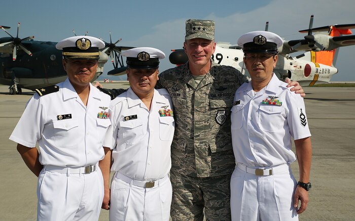 Japan Maritime Self-Defense Force Warrant Officer Ootaki Fumio, first, JMSDF Chief Petty Officer Yukihiro Kamouchi, second, U.S. Air Force Lt. Gen. John L. Dolan, commander of U.S. Forces Japan and 5th Air Force, third, and JMSDF Chief Petty Officer Noriaki Tazaki, fourth, pose at the JMSDF hangar at Marine Corps Air Station Iwakuni, Japan, Sept. 23, 2015. During a visit to the installation, Dolan took time to reconnect with the JMSDF members who saved his life over two decades ago when he was forced to eject from his aircraft 630 nautical miles from Tokyo into the Pacific Ocean.