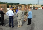 Air Force Brig. Gen. Stan Sheley, second from left, witnesses the expeditionary team in action, receipting material within a sheltered work area with material handling equipment, an administrative trailer and communications satellite.  