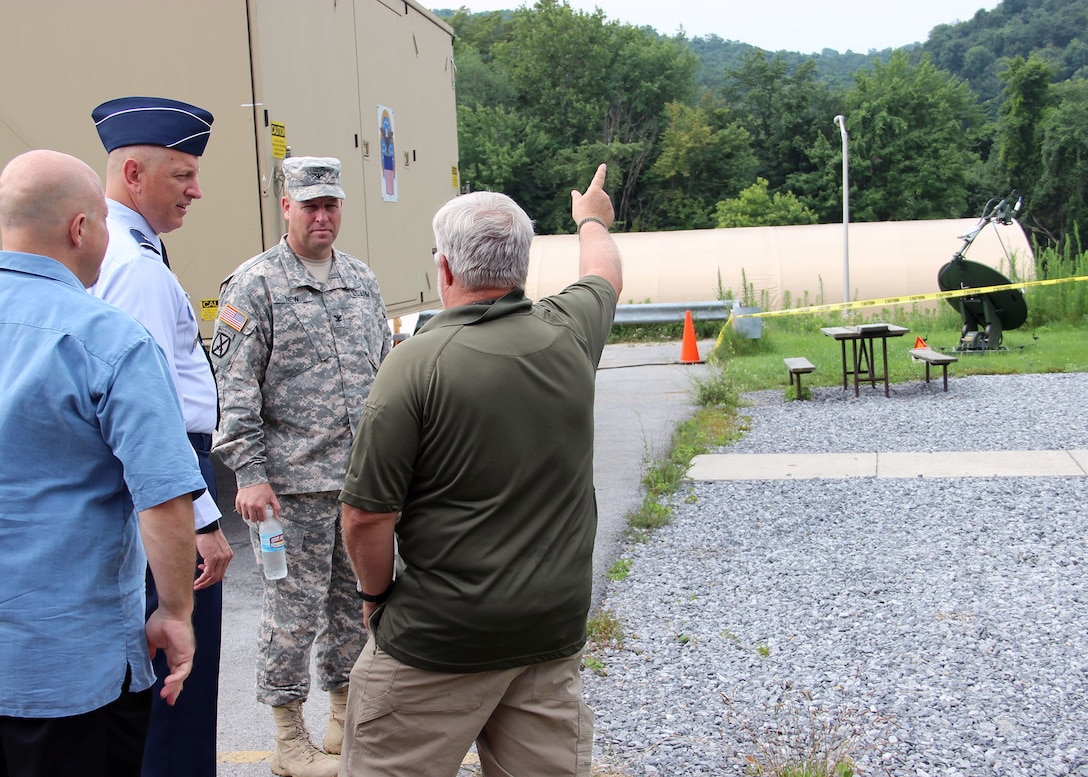 Air Force Brig. Gen. Stan Sheley observes a Very Small Aperture Terminal, or VSAT, a generator powered satellite that is providing the expeditionary team with communication capabilities.  