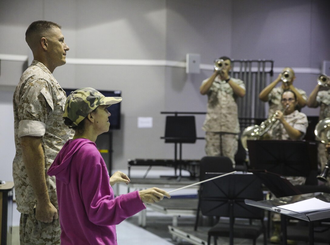 Amber N. Carter, a resident of Hubert, N.C., conducts “The Marines’ Hymn” for the 2nd Marine Division Band during her visit to their rehearsal at the band’s command post at Camp Lejeune, N.C., Sept. 29, 2015. Amber always dreamed of joining the Marine Corps, but could not due to William’s syndrome. Staff Sgt. Isaiah Riley, a mess chief with 10th Marine Regiment, brought her and her family aboard the base to watch the band play. (U.S. Marine Corps photo by Cpl. Paul S. Martinez/Released)