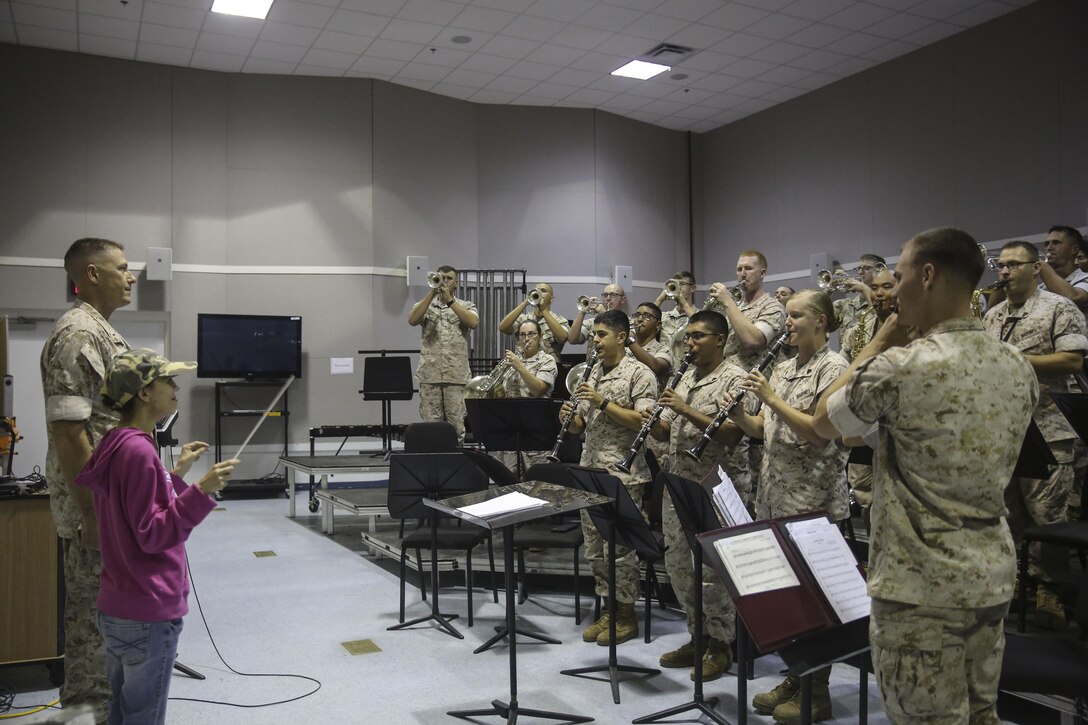 Amber N. Carter, a resident of Hubert, N.C., conducts “The Marines’ Hymn” for the 2nd Marine Division Band during her visit to their rehearsal at the band’s command post at Camp Lejeune, N.C., Sept. 29, 2015. Amber always dreamed of joining the Marine Corps, but could not due to William’s syndrome. Staff Sgt. Isaiah Riley, a mess chief with 10th Marine Regiment, brought her and her family aboard the base to watch the band play. (U.S. Marine Corps photo by Cpl. Paul S. Martinez/Released)