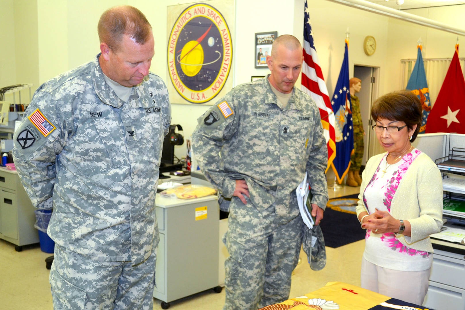 Army Col. Corey New, Defense Logistics Agency Distribution Susquehanna, Pennsylvania commander, and 1st Sgt. Michael Warren, DLA Distribution Susquehanna senior enlisted advisor, are guided on a tour of the DLA Troop Support flag room by its supervisor Hue Nguyen Aug. 26. Photo by Jason Kaneshiro.