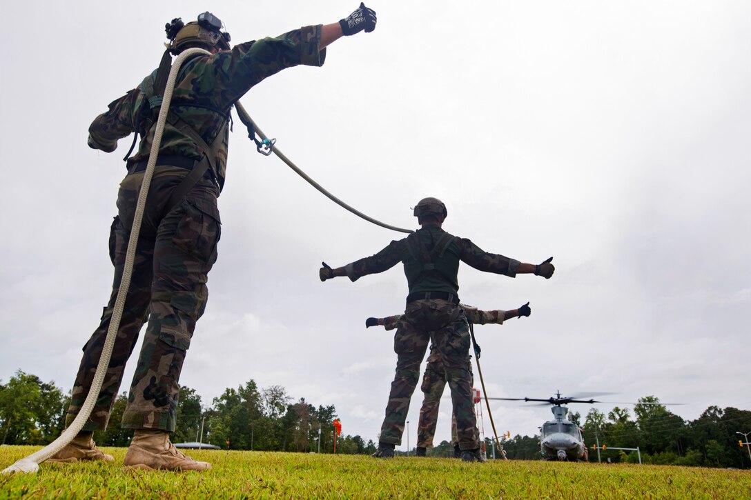 Marines prepare to be lifted by a UH-1Y helicopter during special patrol insertion and extraction training at Stone Bay on Marine Corps Base Camp Lejeune, N.C., Sept. 23, 2015. U.S. Marine Corps photo by Lance Cpl. Austin A. Lewis