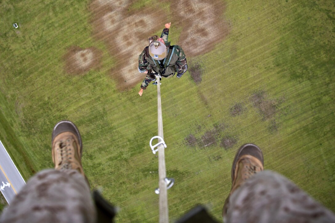 Marines hang from a UH-1Y helicopter during special patrol insertion and extraction training at Stone Bay on Marine Corps Base Camp Lejeune, N.C., Sept. 23, 2015. U.S. Marine Corps photo by Lance Cpl. Austin A. Lewis