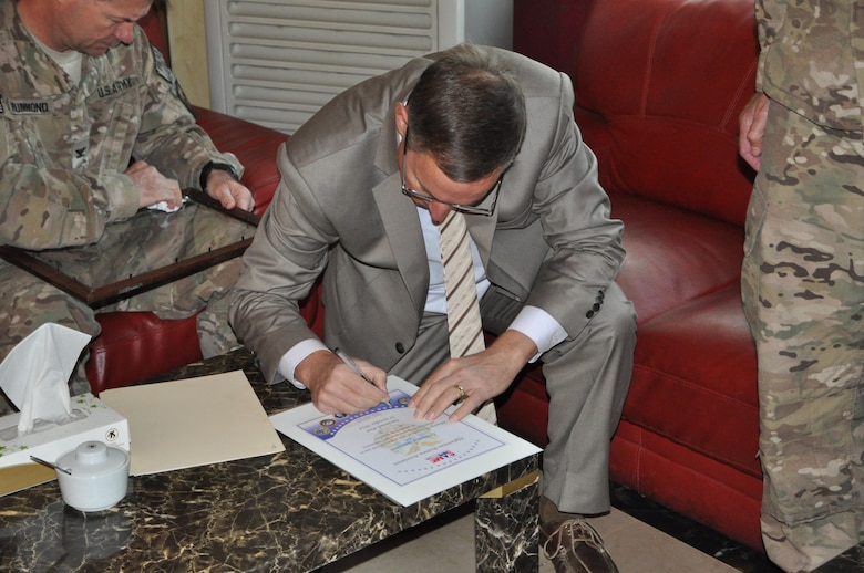 Savannah District's Chief of Engineering Gordon Simmons signs a certificate celebrating the authority of the Afghanistan Builders Association to perform laboratory certifications in accordance with American Society for Testing and Materials standards in October 2014.