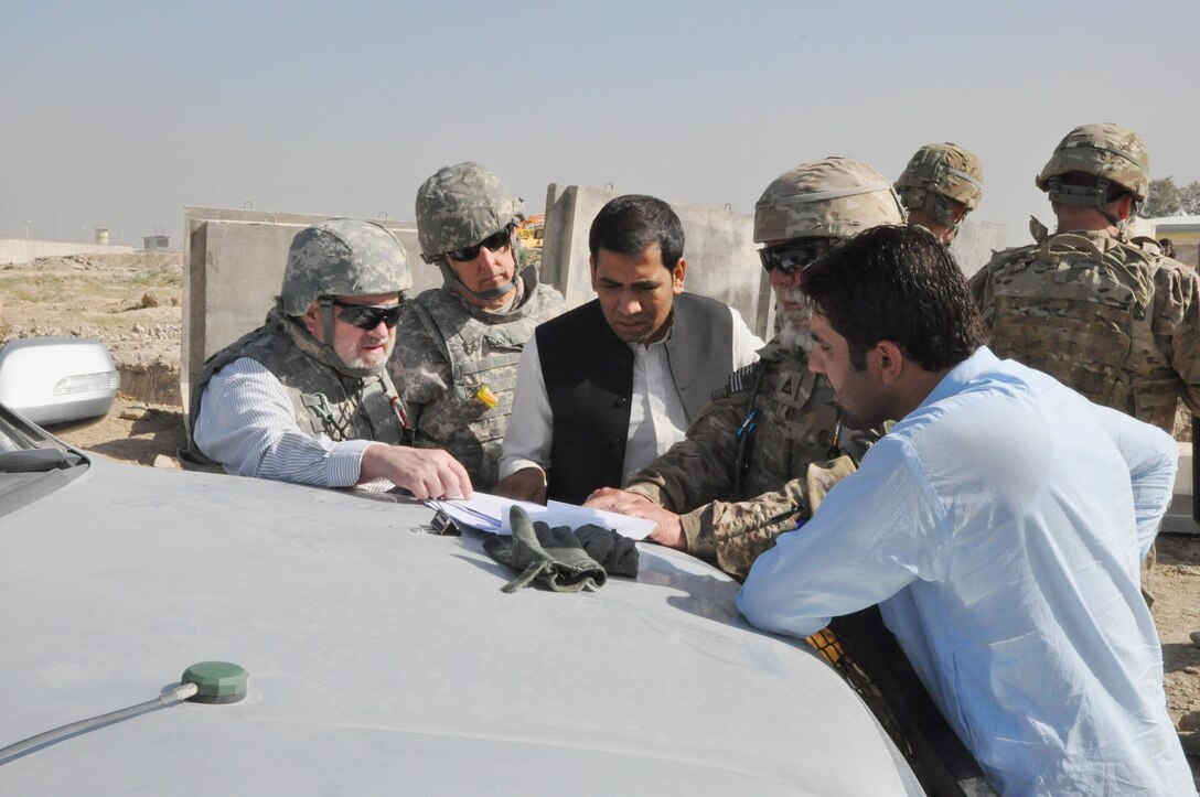 Savannah District's Chief of Engineering Gordon Simmons (second from left), Fort Worth District's Forward Engineering Support Team and local construction representatives review plans for a flood reduction project in Parwan Province, Afghanistan.