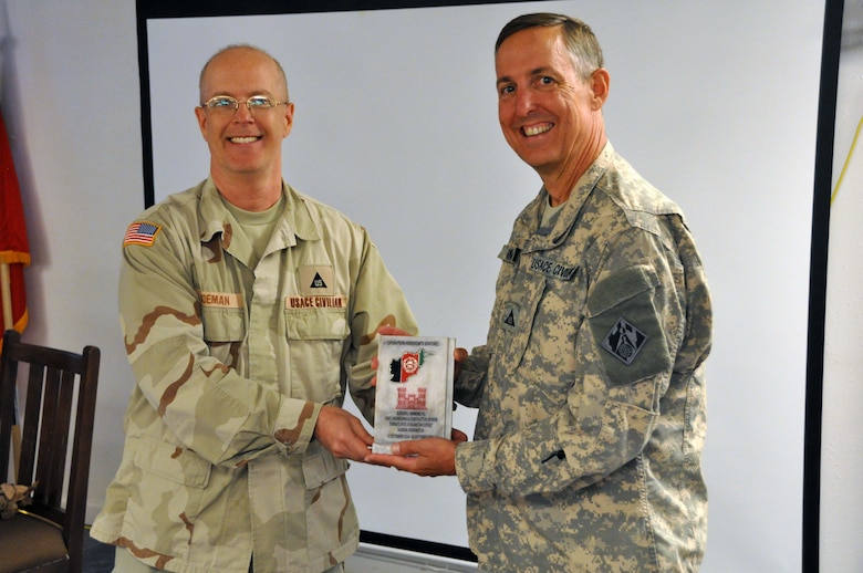 Savannah District's Chief of Engineering Gordon Simmons receives a T-wall plaque  from Construction Branch Chief Norm Boeman in August 2015.