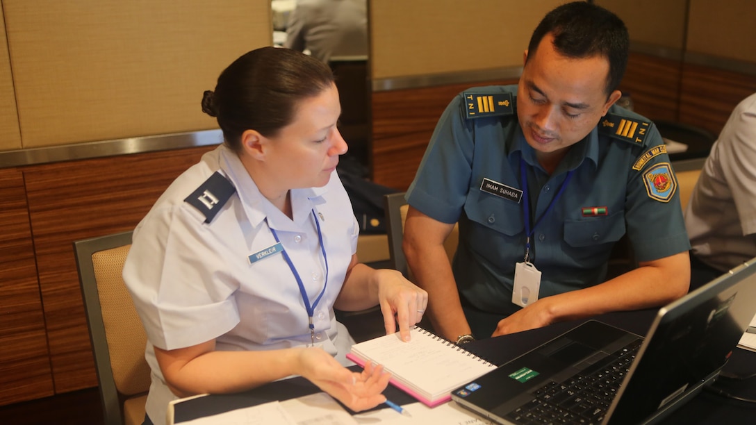 U.S. Air Force Capt. Jodi Verkleir, 36th Medical Support Squadron Readiness Flight commander, discusses a simulated earthquake scenario with Indonesian Capt. Imam Suhada, a medical planner, during Exercise Gema Bhakti in Jakarta, Indonesia, Sept. 16, 2015. Verkleir joined more than 40 U.S. Pacific Command participants during the 10-day bilateral joint exercise designed to promote positive military relations, increase cultural awareness and enhance training and understanding of respective capabilities. U.S. Air Force photo by Matt Lyman