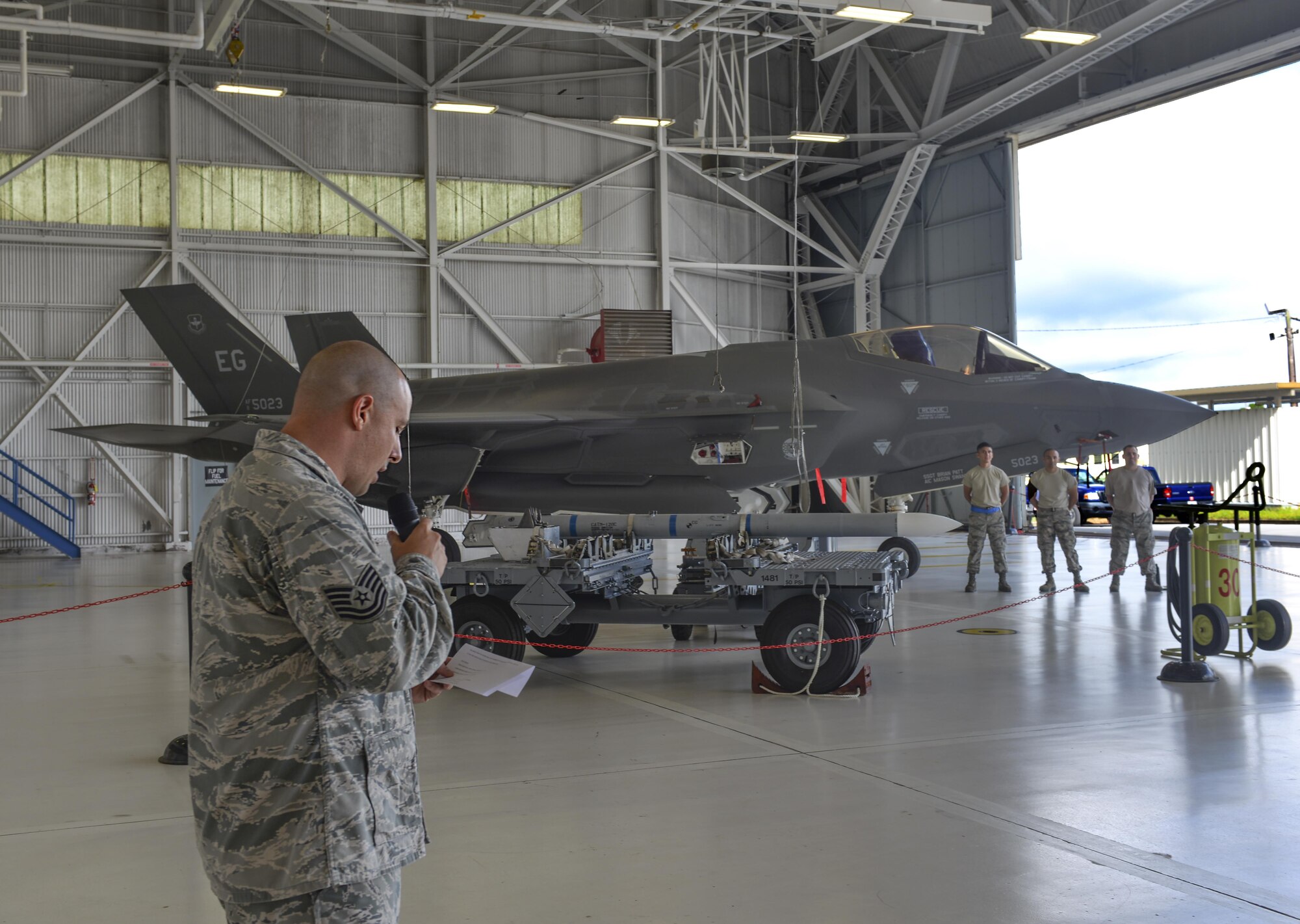 Tech. Sgt. Raymond Mott, 33rd Aircraft Maintenance Squadron loading standardization crew member, officiates a weapons load competition at Eglin Air Force Base, Fla., Sept. 30, 2015. The 33rd AMXS hosts this competition as a morale event to determine who the best load team is in a competitive environment. (U.S. Air Force Photo/Senior Airman Andrea Posey)