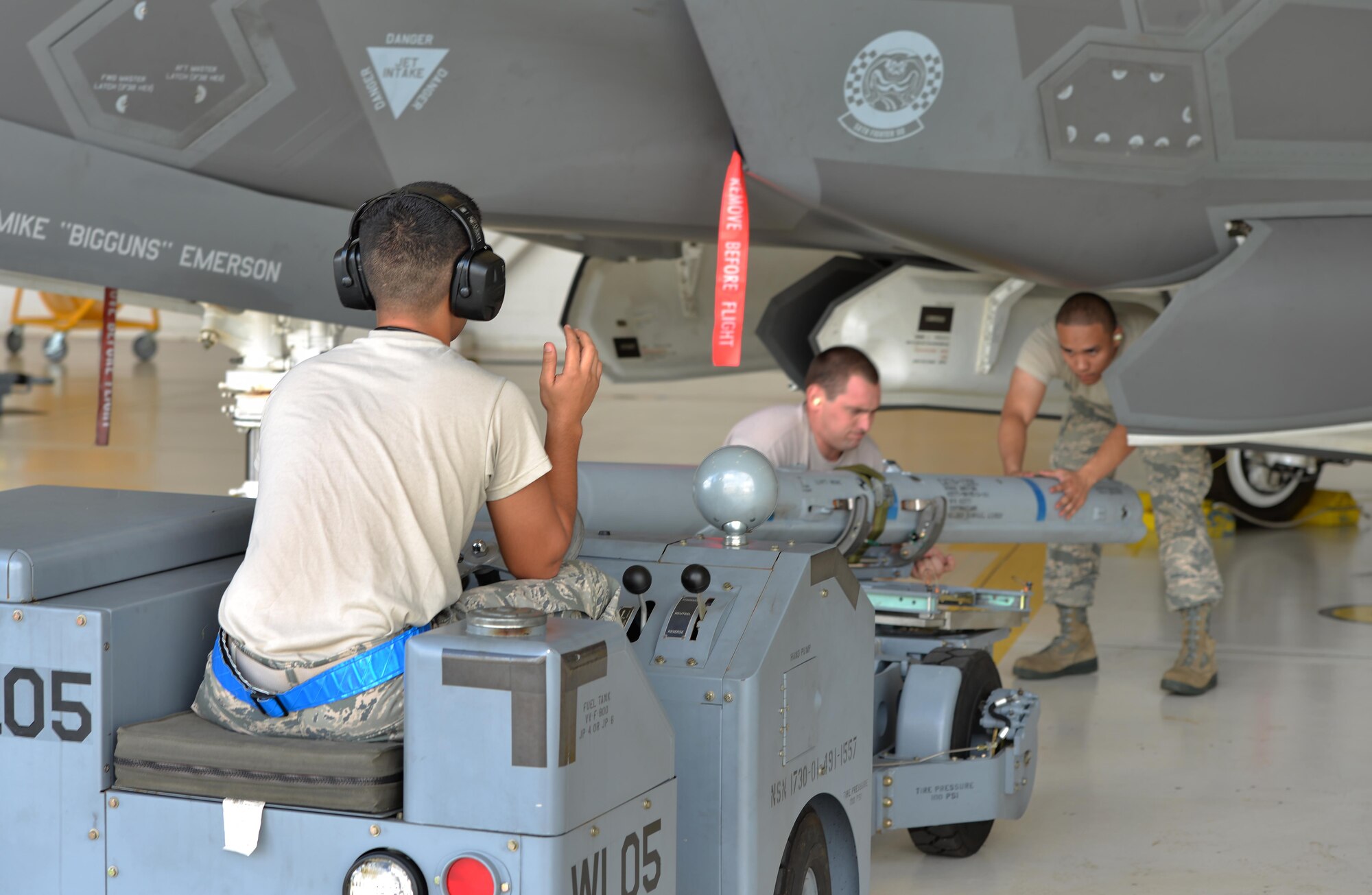 Airmen from the 33rd Aircraft Maintenance Squadron work together to load a missile into an F-35 Lightning II during a weapons load competition at Eglin Air Force Base, Fla., Sept. 30, 2015. Load crew members are evaluated on the level of safety, efficiency and speed displayed while loading munitions. (U.S. Air Force Photo/Senior Airman Andrea Posey)