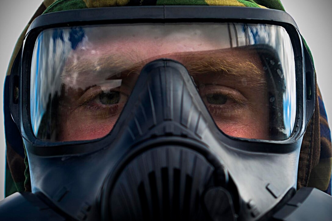 Airman 1st Class Rand McCrady, 36th Munitions Squadron munitions system journeyman, wears an M-50 mask during chemical, biological, radiological and nuclear training Oct. 1, 2015, at Andersen Air Force Base, Guam. Emergency managers teach a CBRN refresher course once a month to Airmen who are preparing for a permanent change of station or deploying to medium or high-threat level duty stations. (U.S. Air Force photo by Senior Airman Joshua Smoot/Released)