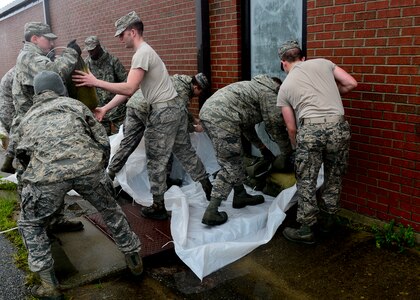 U.S. Air Force Airmen barricade a door with sandbags provided by the 633rd Civil Engineer Squadron at Langley Air Force Base, Va., Oct. 1, 2015. Hurricane Joaquin is projected to affect the local area Oct. 2 through Oct. 5. (U.S. Air Force photo by Airman 1st Class Derek Seifert/ Released)