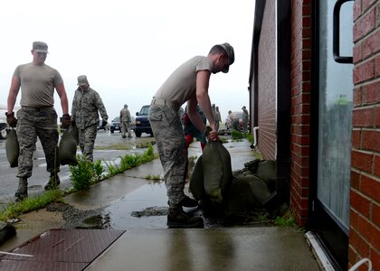 U.S. Air Force Airmen carry sandbags to barricade doors in an effort to prevent water damage at Langley Air Force Base, Va., Oct. 1, 2015. In addition, approximately 40 aircraft and 100 personnel were evacuated to Grissom Air Reserve Base, Ind. (U.S. Air Force photo by Airman 1st Class Derek Seifert/ Released)