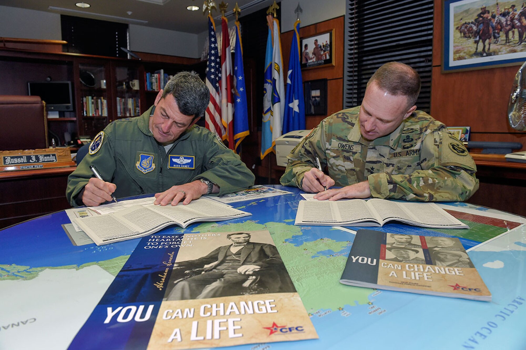Lt. Gen. Russell J. Handy, left, commander, Alaskan Command, U.S. Northern Command; commander, Eleventh Air Force, Pacific Air Forces; and commander, Alaskan North American Aerospace Defense Region, North American Aerospace Defense Command,
and Maj. Gen. Bryan Owens, commander of U.S. Army Alaska, make donations to the Combined Federal Campaign at Joint Base Elmendorf-Richardson Wednesday. The CFC, which provides opportunities for federal employees to give to charities of their choice, is the largest and most successful workplace giving campaign in the world. (U.S. Air Force photo/Alejandro Pena)