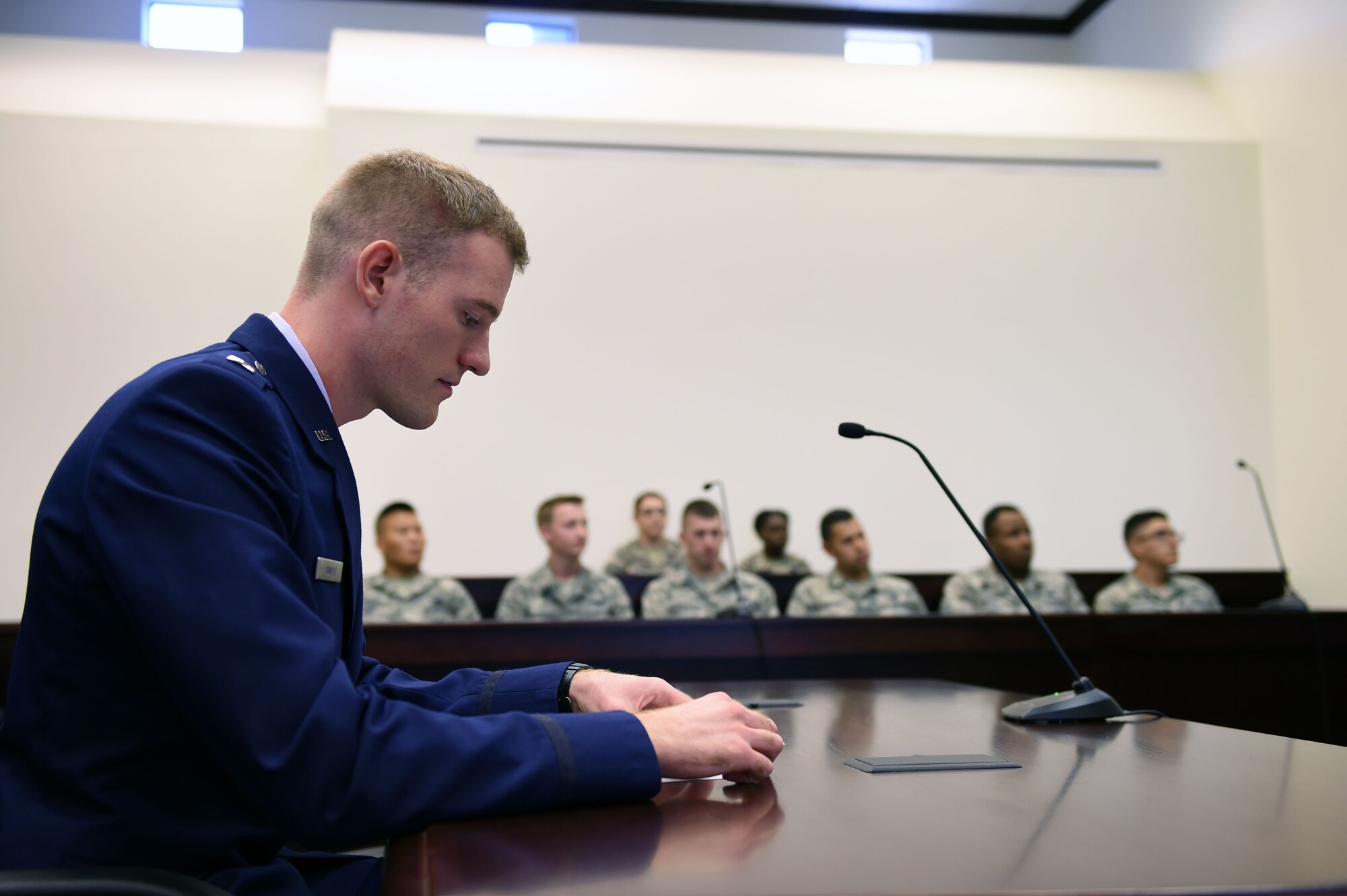 1st Lt. Ryan Sample, 62nd Airlift Wing judge advocate, reads a script during a mock sexual assault trial inside the McChord Field court room Sept. 29, 2015, at Joint Base Lewis-McChord, Wash. Sample and the 62 AW legal office conducted their legal training by simulating a mock trial with Airmen from the First Term Airmen Center, where they served as panel members and listened to evidence and testimony. (Air Force photo/Senior Airman Naomi Griego)