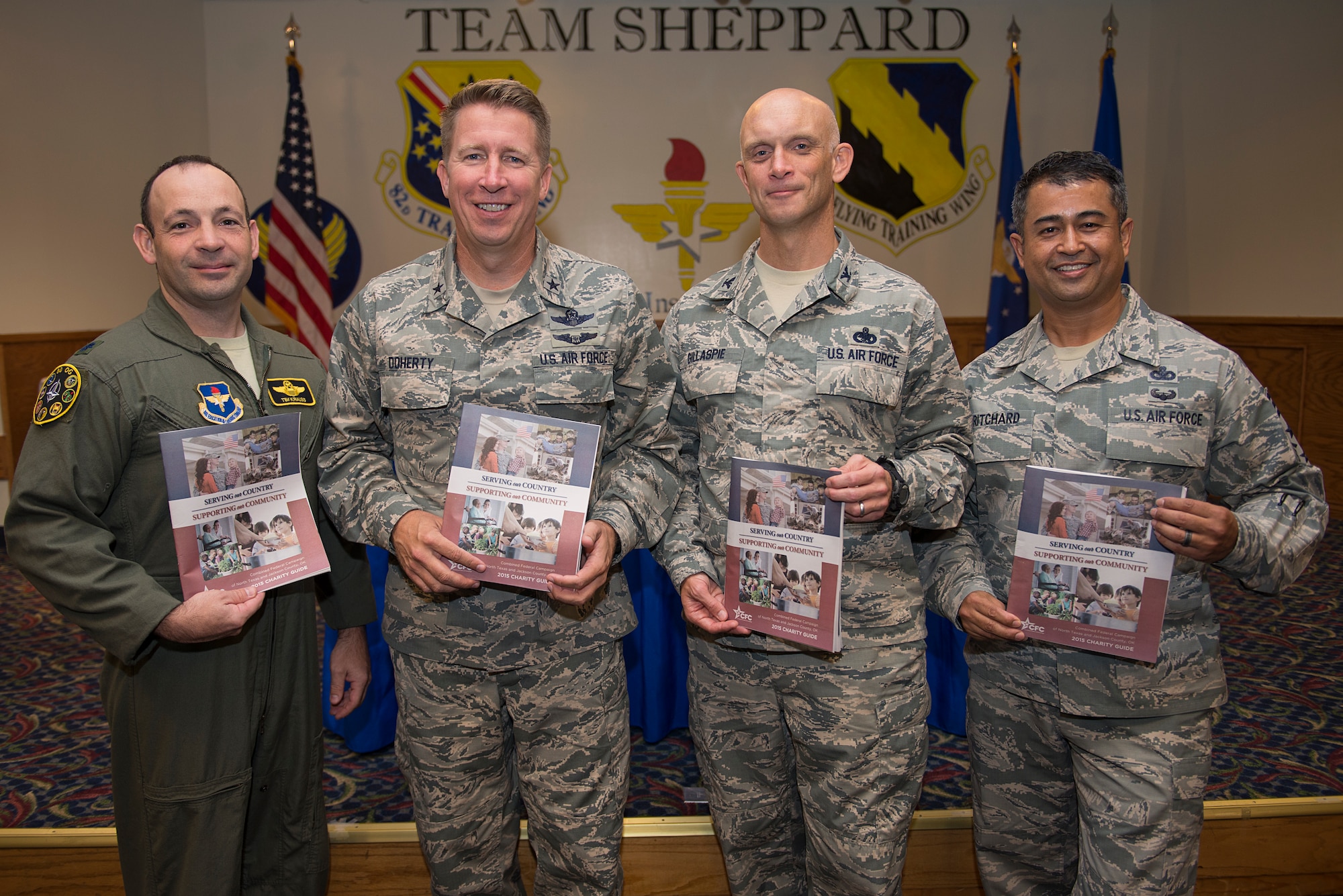 Lt. Col. Timothy Krauss, 80th Operations Group deputy commander, Brig. Gen. Patrick Doherty, 82nd Training Wing commander, Col. Timothy Gillaspie, 82nd TRW vice commander, and Chief Master Joseph Pritchard, 82nd TRW command chief, hold their Combined Federal Campaign charity guide after making their donation at Sheppard Air Force Base, Texas, Oct. 1, 2015. Sheppard leadership kicked off the campaign by making the first donation during the CFC breakfast. (U.S. Air Force photo/Senior Airman Kyle Gese)