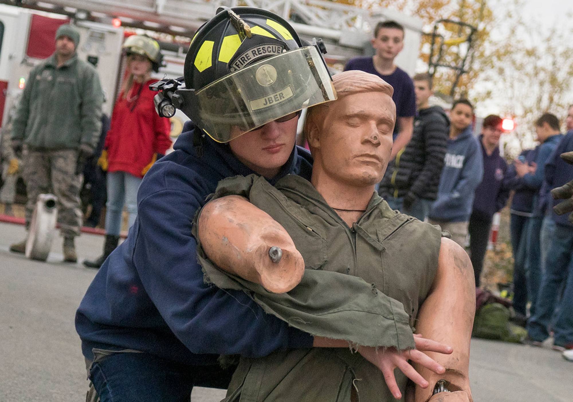 John Timmins, a sophomore in the Eagle River High School JROTC program, carries a dummy during firefighting demo challenge  while visiting Airmen assigned to the 673d Civil Engineer Squadron on Joint Base Elmendorf-Richardson Sept. 25. (U.S. Air Force photo/Justin Connaher)