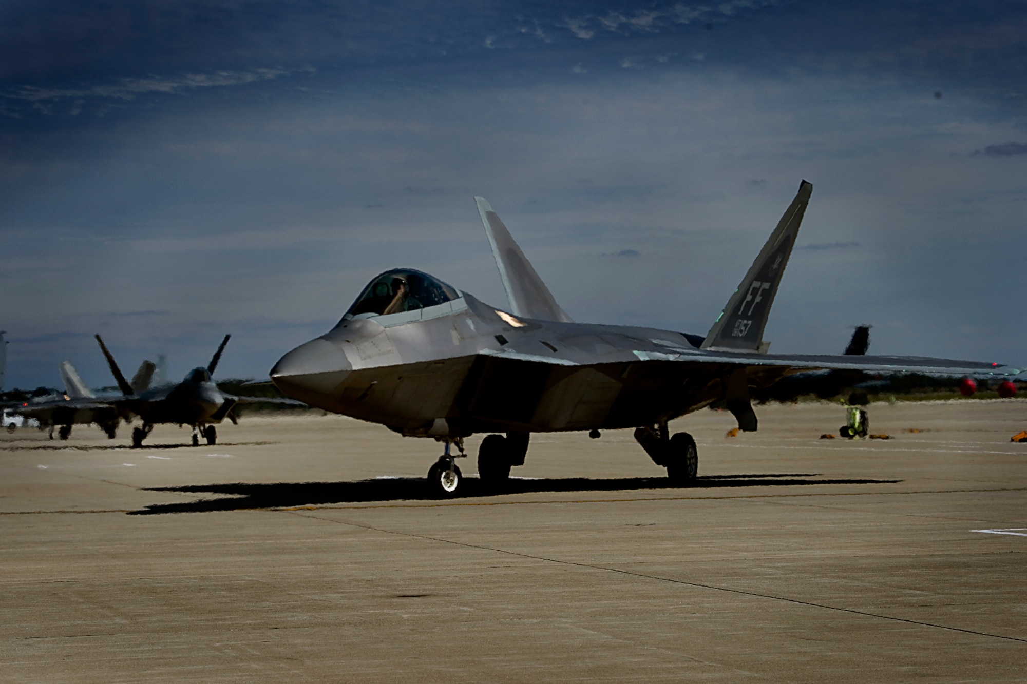 The first of 34 F-22 Raptors is marshalled into a parking spot at Grissom Air Reserve Base, Ind., Oct. 1, 2015. The F-22s and eight T-38 Talons from Joint Base Langley-Eustis, Va. arrived at Grissom to seek shelter from Hurricane Joaquin, a powerful storm building in the Atlantic. (U.S. Air Force photo/Douglas Hays)