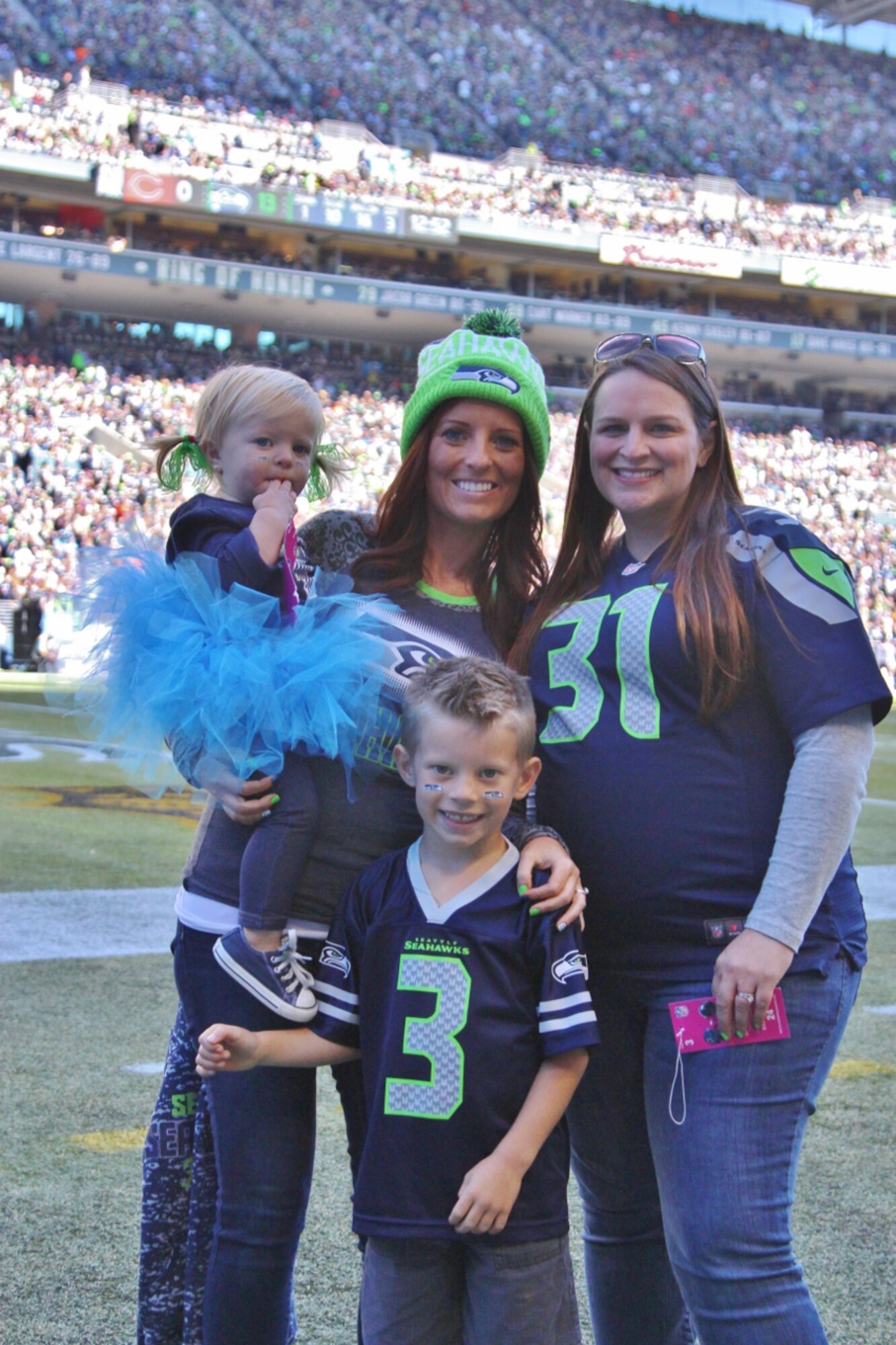 The family of Master Sgt. Jacob Elliott, 62nd Maintenance Group first sergeant stationed at Joint Base Lewis-McChord who is currently stationed overseas, pose for a photo Sept. 27, 2015, at CenturyLink Field in Seattle, Wash. A shout-out video from Elliot was played during the Seattle Seahawks homecoming game as part of their Salute to Service program. (Courtesy photo)