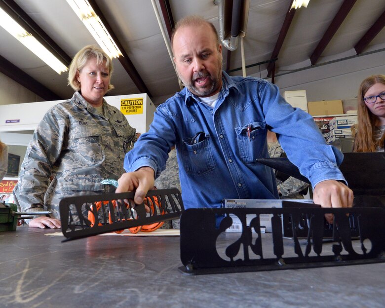 Troy Torres, Ellicott High School welding instructor, shows his students’ welding projects to Col. DeAnna M. Burt, 50th Space Wing commander, during a tour of Ellicott School District in Ellicott, Colorado, Wednesday, Sept. 30, 2015. The projects made by the welding students will be featured and sold in the district’s November craft show. (U.S. Air Force photo/Staff Sgt. Debbie Lockhart)