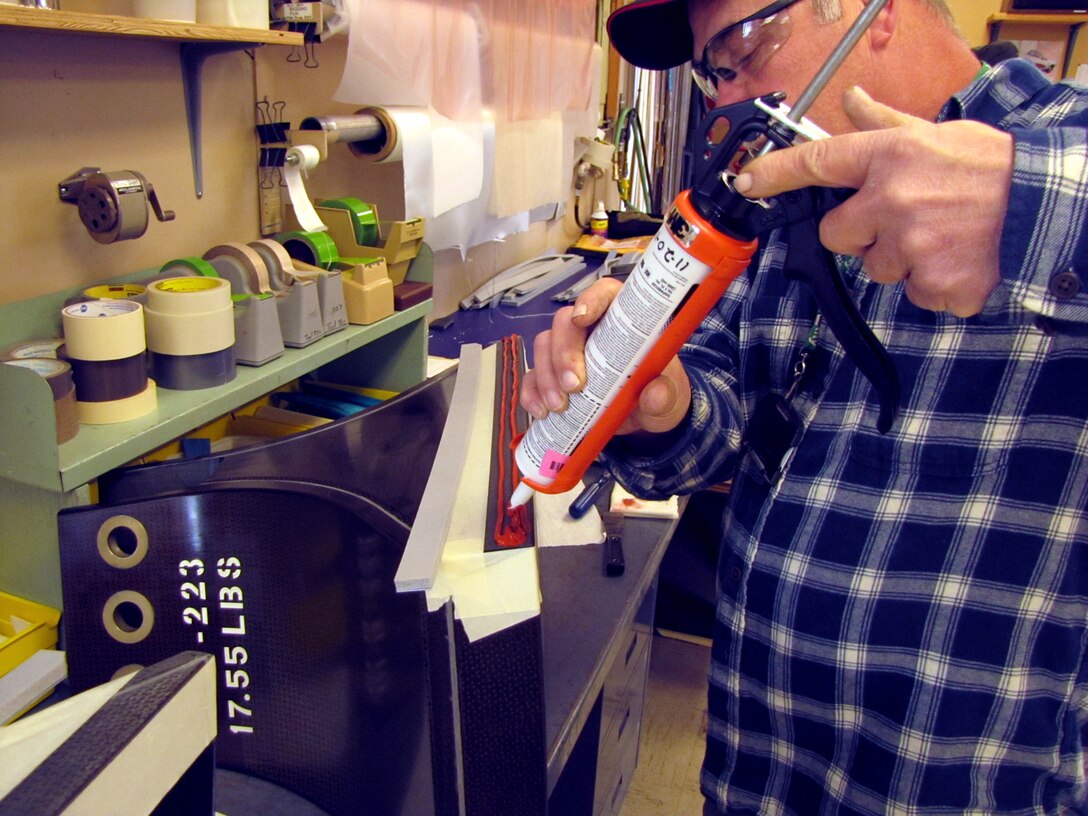 An AEDC craftsman applies adhesive to bond foam seal to a spacer for one of the axial flow compressors used to run the large wind tunnels at AEDC. A two-man Blade Shop has been heading up the repair of the rotor blades and spacers for the axial flow compressors in the AEDC Propulsion Wind Tunnel facility. (Photo provided)